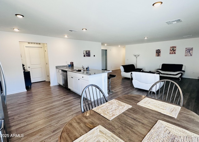 dining room featuring wood finished floors, recessed lighting, and baseboards