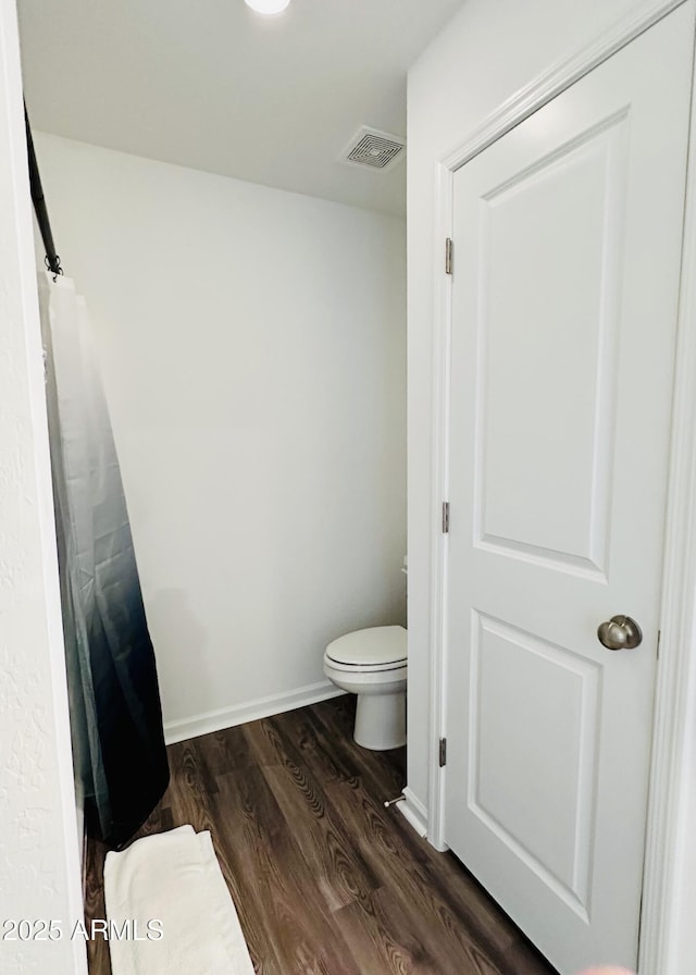 bathroom featuring wood finished floors and toilet