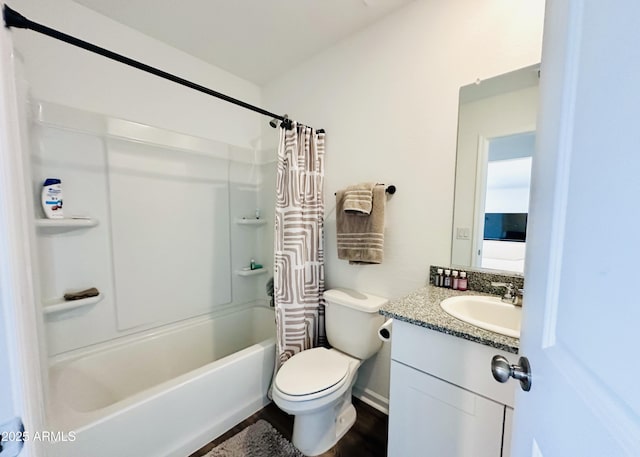bathroom with toilet, vanity, shower / bath combo, wood finished floors, and baseboards