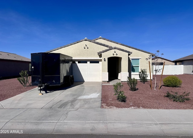 view of front of home featuring a garage, concrete driveway, and stucco siding