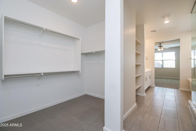 walk in closet with carpet and ceiling fan