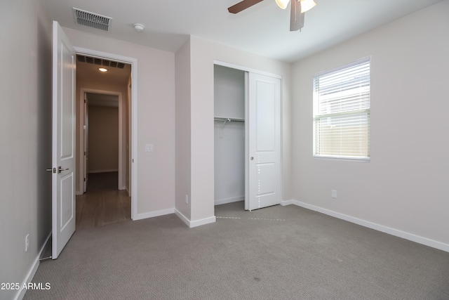 unfurnished bedroom with carpet flooring, baseboards, visible vents, and a closet
