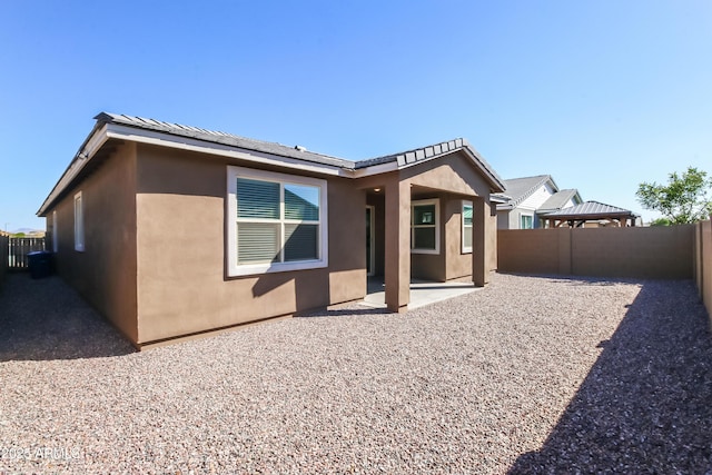 back of house with a gazebo, a patio, a fenced backyard, and stucco siding