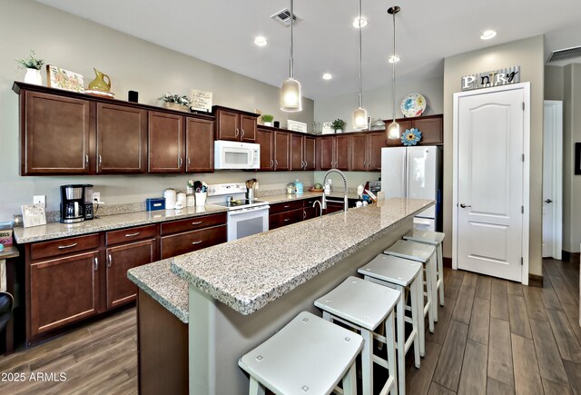 932 N Gomez St, Dewey, AZ 86327 - kitchen with white appliances, dark wood finished floors, a breakfast bar, pendant lighting, and recessed lighting