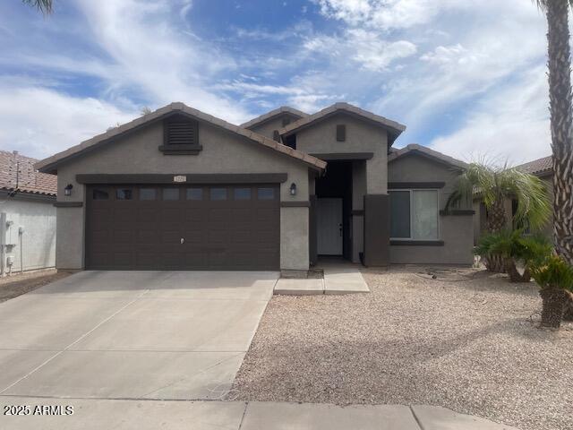single story home with a garage, stucco siding, and driveway