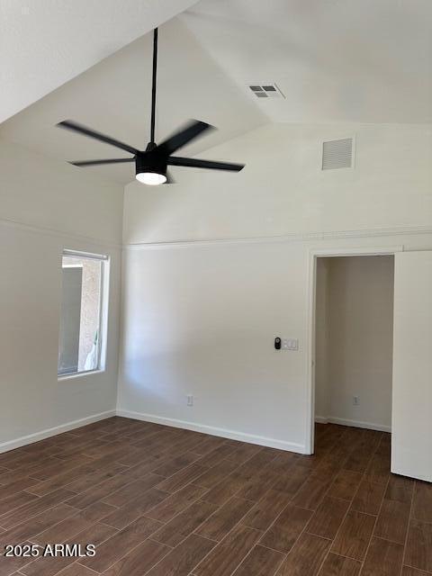 spare room featuring ceiling fan, vaulted ceiling, dark wood-style flooring, and visible vents