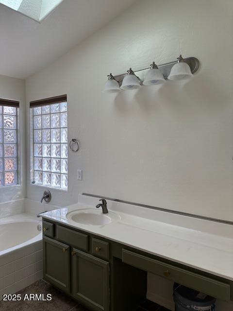 bathroom featuring a garden tub and vanity