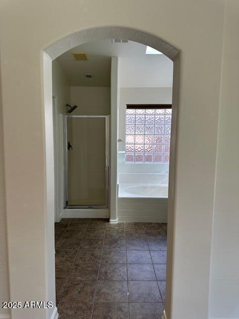 bathroom with a shower stall, a bath, and visible vents
