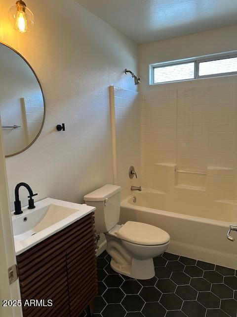 bathroom featuring tile patterned flooring,  shower combination, toilet, and vanity