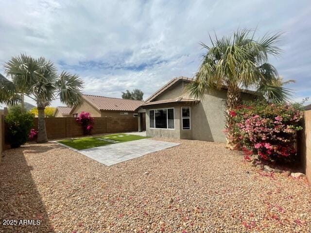 back of property featuring a fenced backyard, a patio, and stucco siding