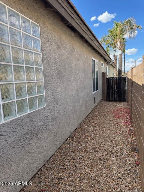 view of home's exterior featuring fence and stucco siding