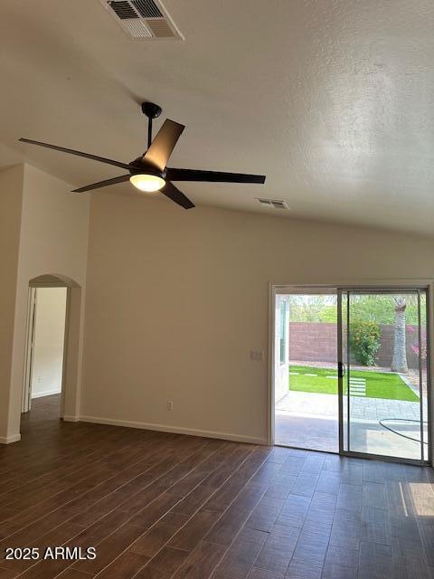 unfurnished room with arched walkways, ceiling fan, visible vents, and dark wood-style floors