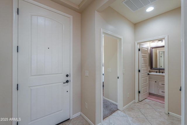 entryway featuring light tile patterned flooring and sink