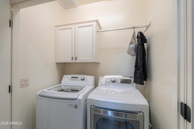 laundry room with cabinets and washer and clothes dryer