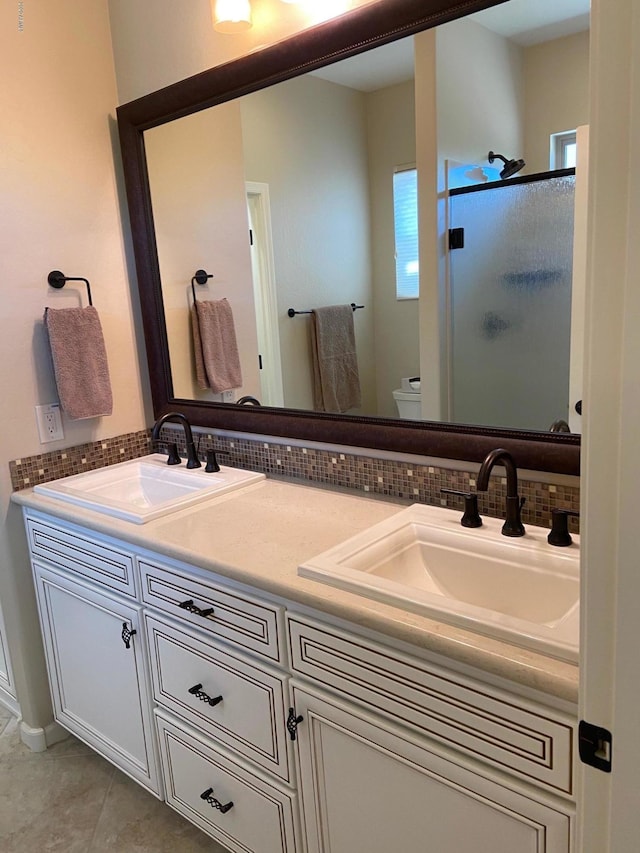 bathroom with vanity, decorative backsplash, tile patterned floors, toilet, and walk in shower