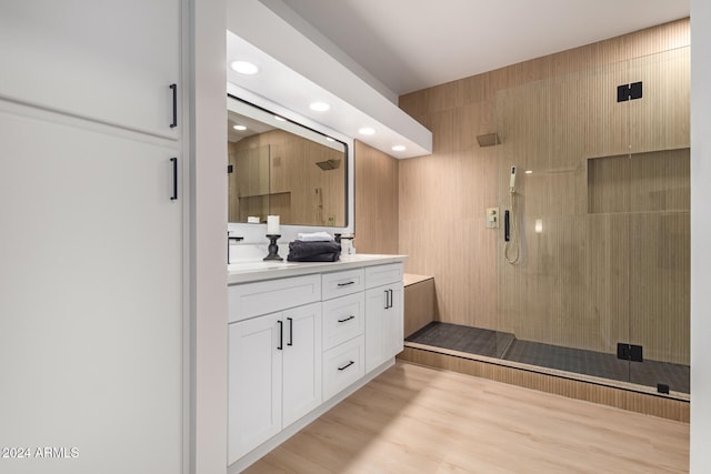 bathroom featuring hardwood / wood-style floors, vanity, and a tile shower