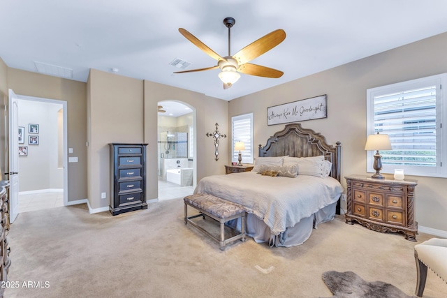 bedroom featuring light carpet, connected bathroom, and ceiling fan