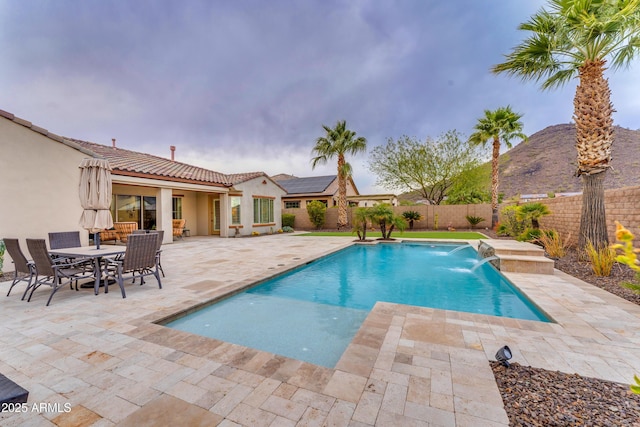 view of swimming pool with pool water feature and a patio