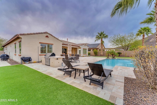 view of pool with a patio area, pool water feature, a yard, and area for grilling