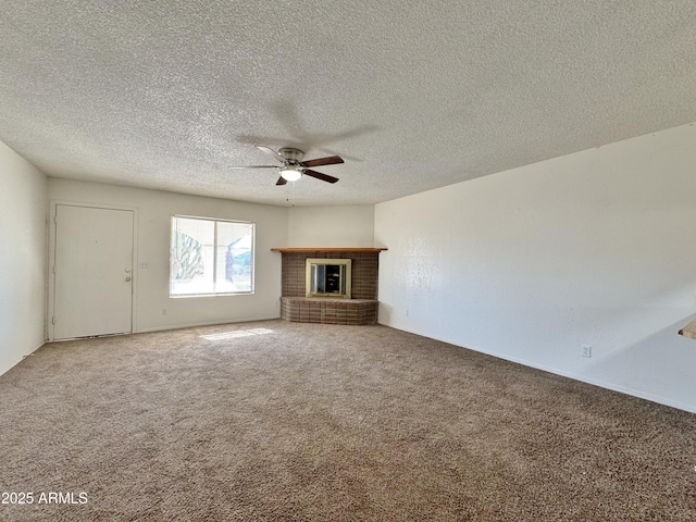 unfurnished living room featuring carpet, ceiling fan, a fireplace, and a textured ceiling