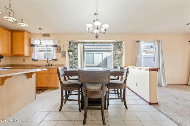 dining room featuring a notable chandelier, light colored carpet, and sink