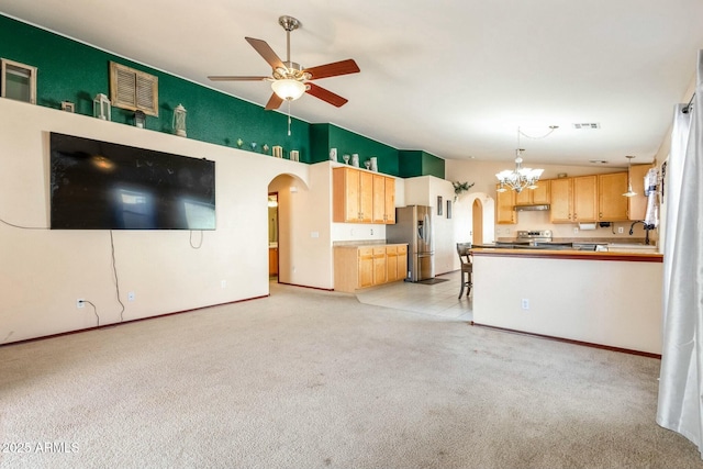 unfurnished living room with lofted ceiling, sink, ceiling fan with notable chandelier, and light carpet