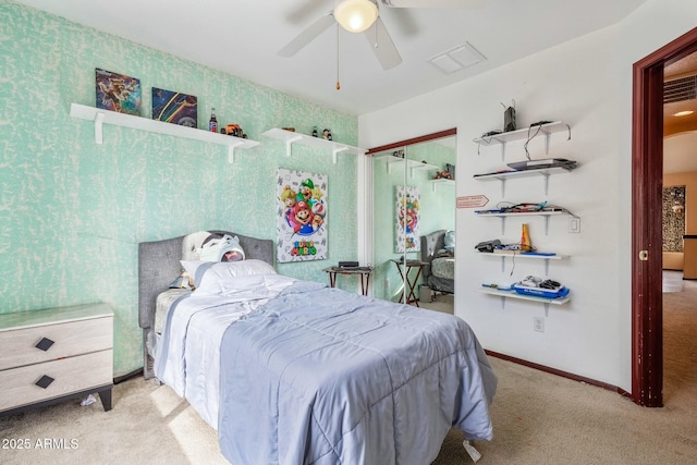 bedroom with light colored carpet, ceiling fan, and a closet