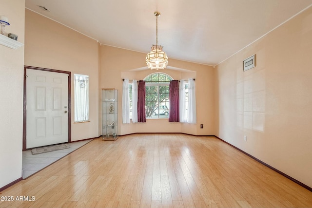 foyer with lofted ceiling, a notable chandelier, and light hardwood / wood-style floors