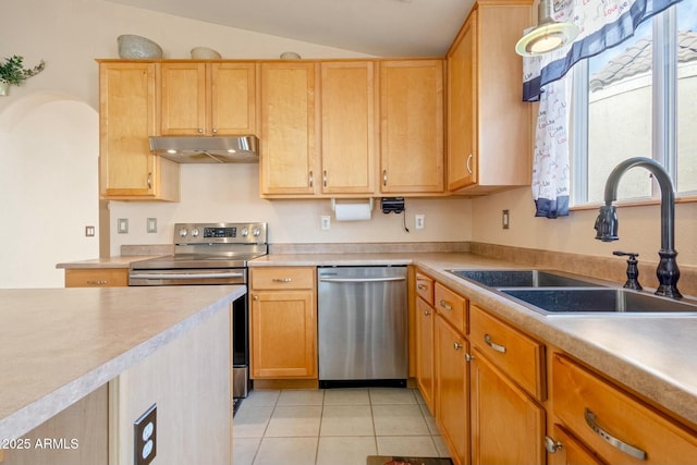 kitchen featuring light tile patterned flooring, sink, vaulted ceiling, light brown cabinets, and stainless steel appliances