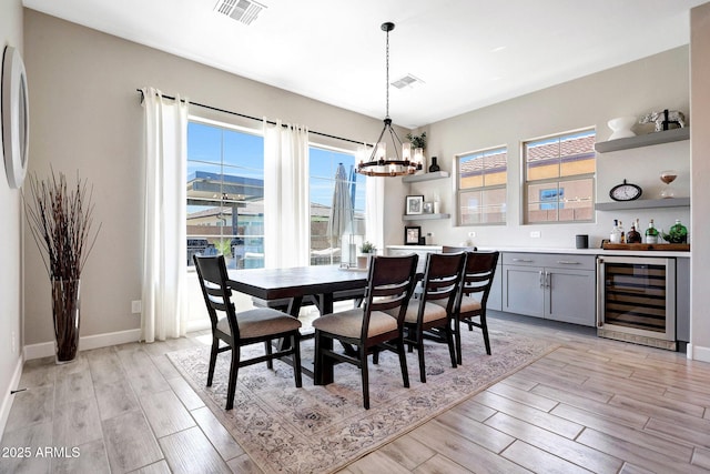 dining area with beverage cooler, visible vents, and a healthy amount of sunlight