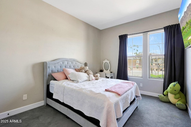bedroom with dark colored carpet and baseboards