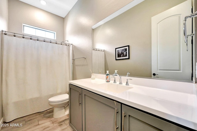 bathroom with toilet, wood finished floors, shower / tub combo, and vanity
