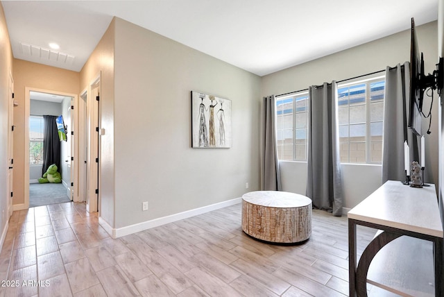 office space with baseboards, light wood-style flooring, and visible vents