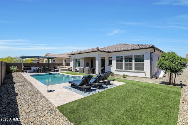 back of property with a tile roof, a lawn, a patio area, an outdoor hangout area, and a fenced backyard