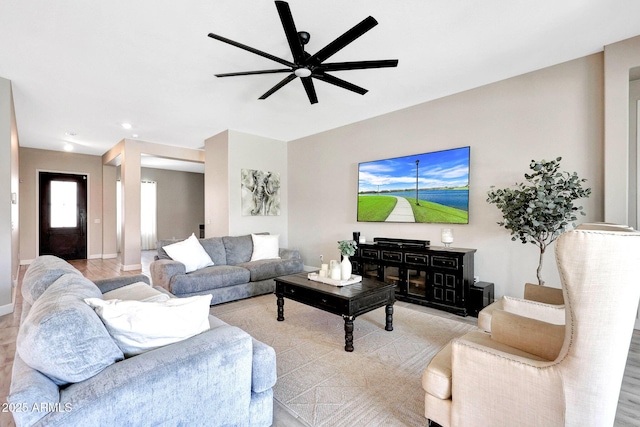 living room with ceiling fan and baseboards