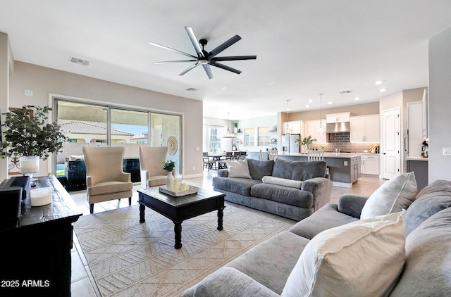 living room featuring ceiling fan, recessed lighting, and visible vents