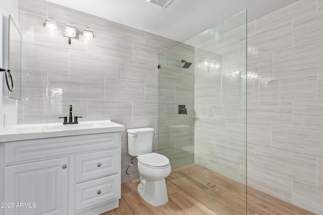 full bath with walk in shower, toilet, vanity, and tile walls