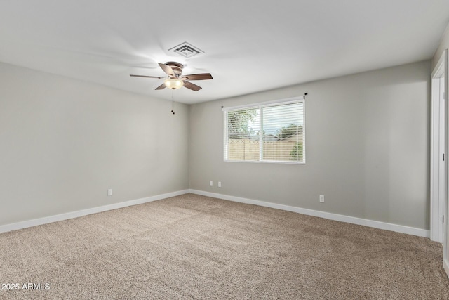 carpeted empty room featuring ceiling fan and baseboards