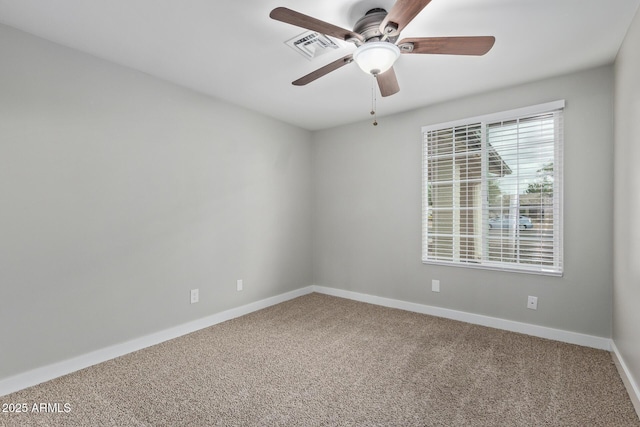 carpeted spare room with a ceiling fan and baseboards
