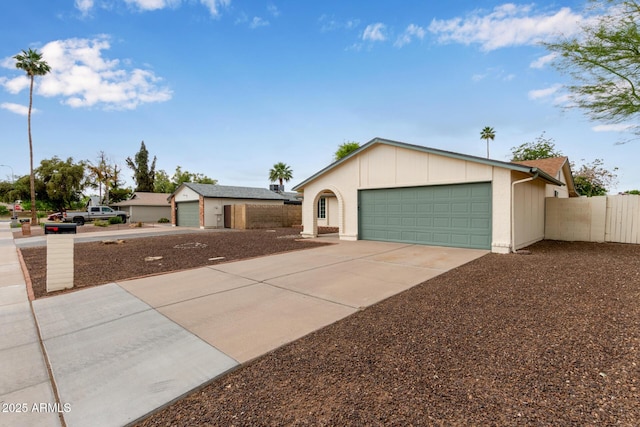 ranch-style house with fence, driveway, and an attached garage