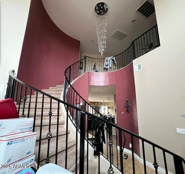 stairs featuring an inviting chandelier and a high ceiling