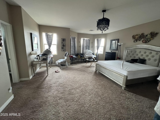 carpeted bedroom featuring a notable chandelier