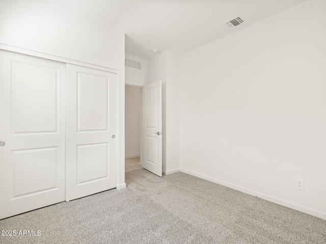 unfurnished bedroom featuring light carpet, baseboards, visible vents, and a closet