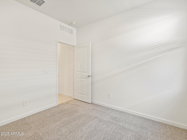 empty room featuring carpet flooring, visible vents, and baseboards