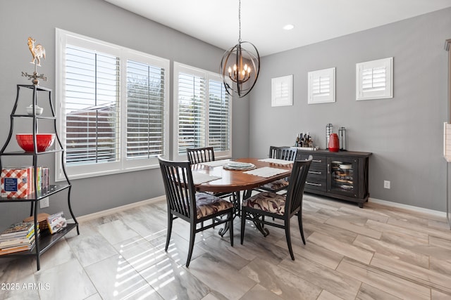 dining space with baseboards and a notable chandelier