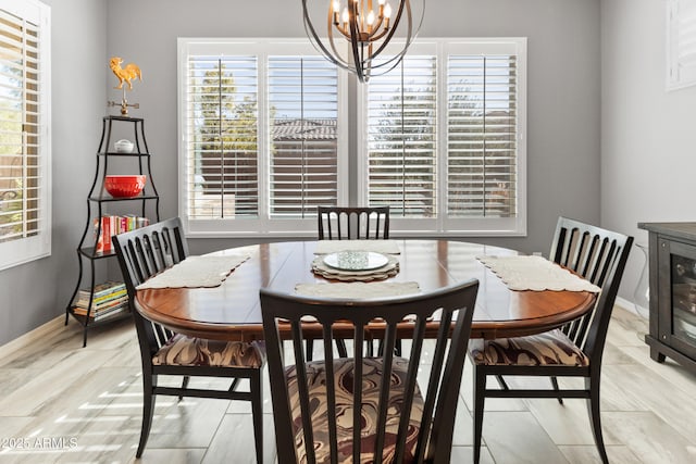 dining room with baseboards, plenty of natural light, and an inviting chandelier