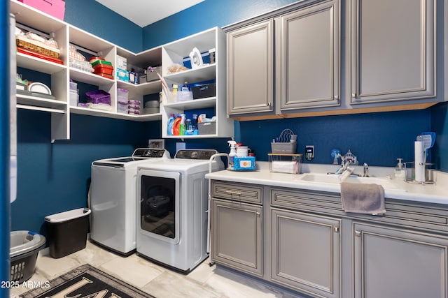 laundry room featuring cabinet space, a sink, and separate washer and dryer