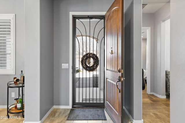 foyer featuring a healthy amount of sunlight and baseboards