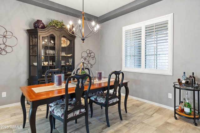 dining space with baseboards, a chandelier, and wood finished floors