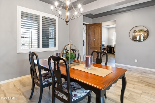 dining space featuring a notable chandelier, light wood-type flooring, and baseboards